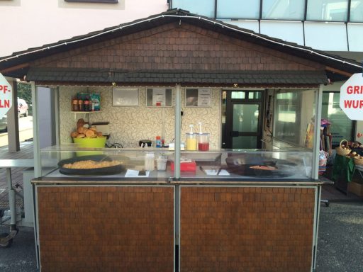 Snackstand mit Holzverkleidung, verkauft Würstchen und Snacks.